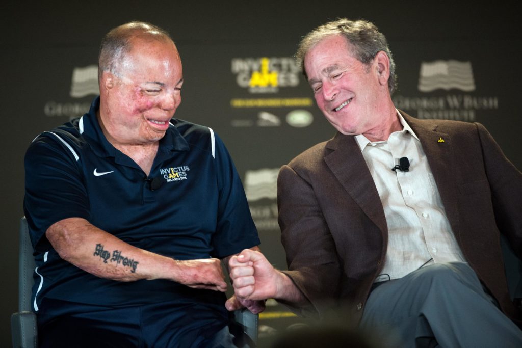 Former President George W. Bush fist bumps with Air Force Master Sgt. Israel Del Toro during the 2016 Invictus Games Symposium on Invisible Wounds in Orlando, Fla., May 8, 2016. The symposium, hosted by Bush and Britain’s Prince Harry, sought to destigmatize the victims of post-traumatic stress and other injuries that are not readily visible. DoD photo by EJ Hersom 