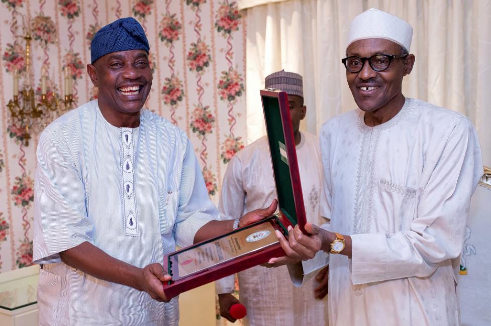 e‬ President Buhari presenting a gift to Outgoing Inspector General of Police IG Solomon Arase